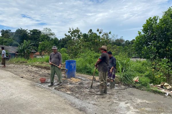 Warga Desa Kombangan bergotong royong melakukan perbaikan jalan yang menghubungkan Desa Kombangan dan Desa Katol, Kecamatan Geger, Kabupaten Bangkalan, Selasa (20/5/2025).