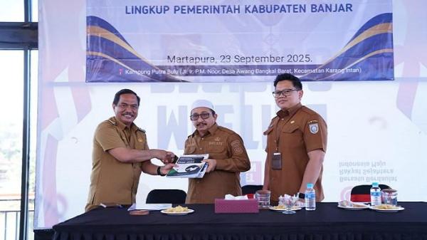 Kepala DKISP Banjar, HM Aidil Basith menyerahkan buku 