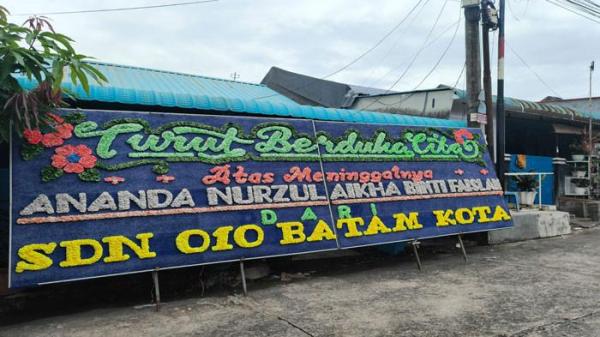 KARANGAN BUNGA - Karangan bunga belasungkawa dari SDN 010 Batam Kota atas meninggalnya siswi mereka, Nur Zulaikha (10) akibat kecelakaan maut di Batam, Sabtu (4/10/2025).