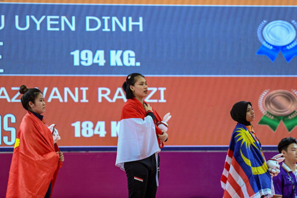 Lifter putri Indonesia Tsabitha Alfiah Ramadani (kedua kiri) mengikuti upacara penyerahan medali angkat besi 64 kg putri SEA Games 2023 di Taekwondo Hall, Olympic Complex, Phnom Penh, Kamboja, Senin (15/5/2023). Foto: Muhammad Adimaja/Antara Foto
