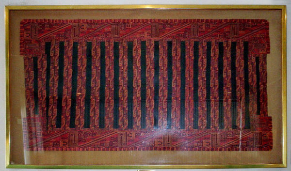 Mantel upacara dari Peru ini merupakan tekstil langka yang ditemukan di pemakaman Paracas di Peru selatan. Karena iklim yang kering, mantel ini ditemukan dalam kondisi terawetkan yang luar biasa pada tahun 1930-an dan diperkirakan berusia 2.000 hingga 3.000 tahun. Benda bersejarah ini dihadiahkan oleh Peru untuk PBB pada 1957 dan dipajang di Indonesian Lounge. Foto: United Nations Gifts
