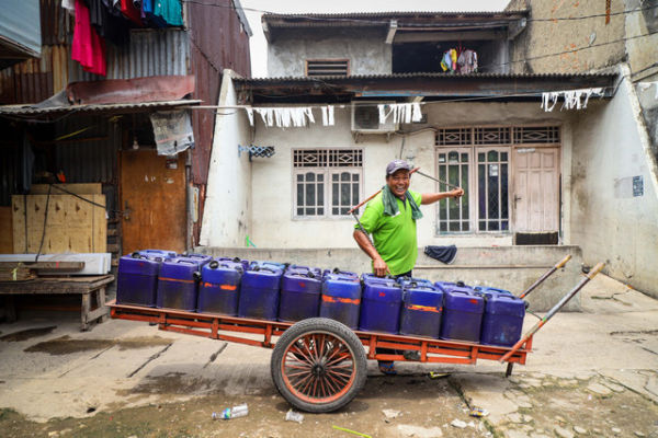 Seorang pedagang air bersih keliling di Kampung Apung, Kapuk Teko, Kalideres, Jakarta Barat. Foto: Iqbal Firdaus/kumparan