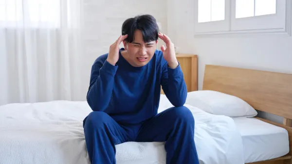 प्रकाश संवेदनशीलतेच्या लक्षणासह मायग्रेन असलेला माणूस