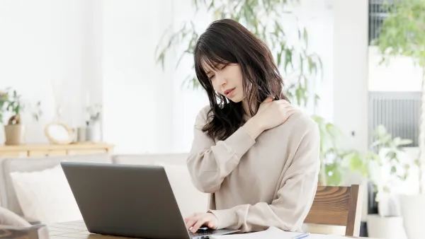 ताठरपणाच्या लक्षणांसह मायग्रेन असलेली स्त्री