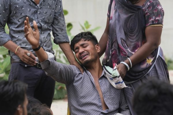 Một người dân Ấn Độ có em trai 14 tuổi thiệt mạng, khóc bên ngoài phòng khám nghiệm tử thi của bệnh viện ở Ahmedabad ngày 13/6. Ảnh: AP