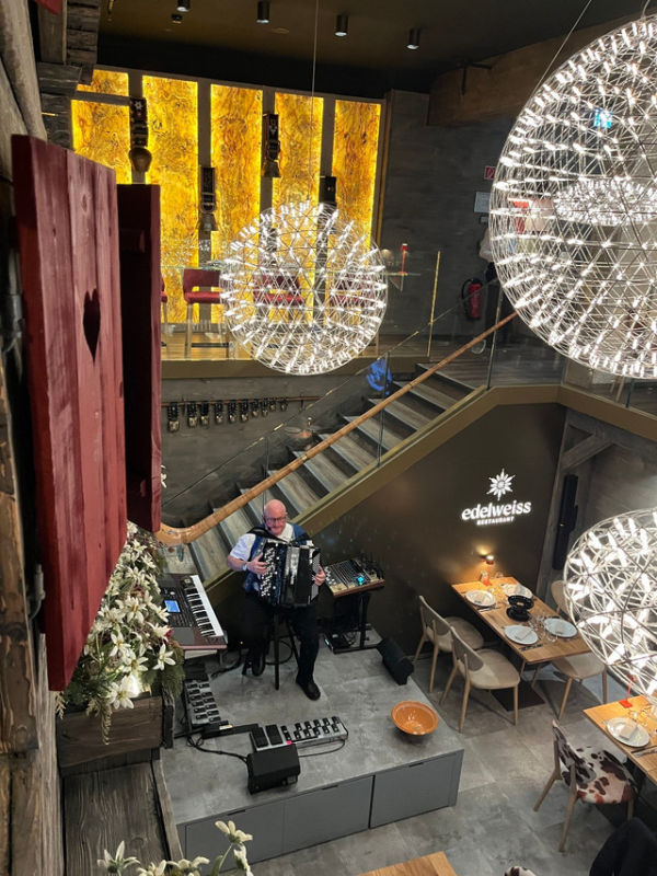 Seorang musisi menghibur pengunjung restoran dengan memainkan musik-musik tradisional Swiss. Foto: Adhie Ichsan/kumparan