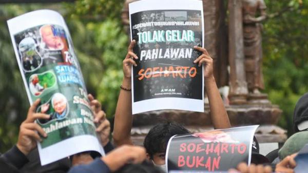 Aliansi Warga Malang (Awam) membentangkan poster menolak Soeharto menjadi pahlawan nasional
