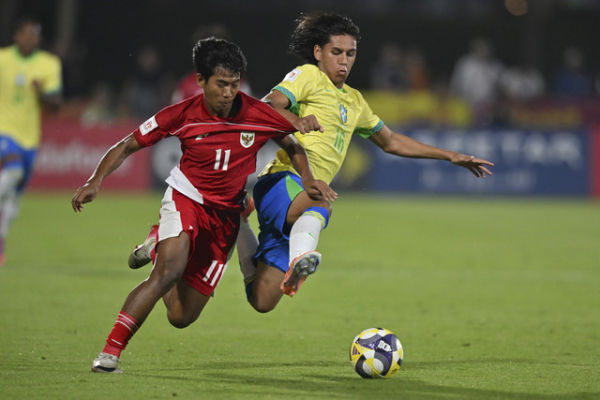 Pemain Timnas Indonesia U-17 Dimas Adi (kiri) berebut bola dengan pesepak bola Timnas Brasil U-17 Arthur Ryan (kanan) pada laga Grup H Piala Dunia U-17 di Lapangan 7 Aspire Zone, Doha, Qatar, Jumat (7/11/2025). Foto: Bayu Pratama S/ANTARA FOTO