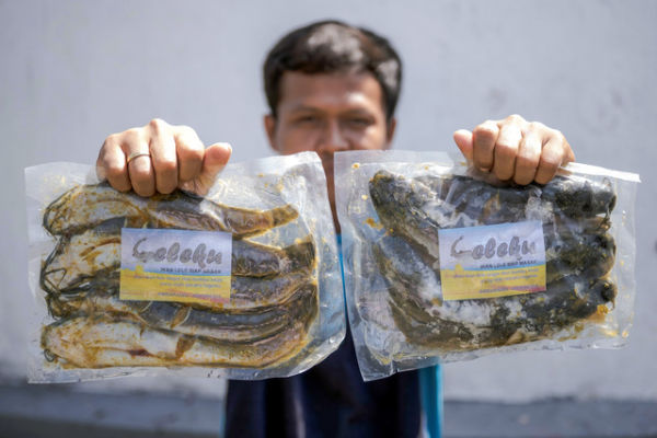 Warga binaan pemasyarakatan (WBP) menunjukkan produk ikan lele kemasan siap goreng yang dibudidayakan di dalam Lapas. Foto: Aprillio Akbar/ANTARA FOTO