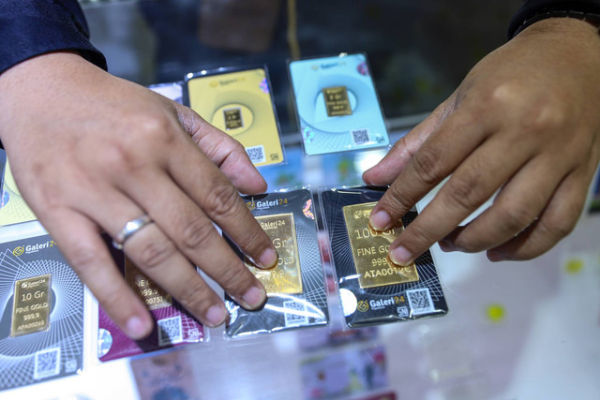 Petugas menunjukan logam mulia emas di kantor Galeri 24 Pegadaian, Kamis (18/4/2024). Foto: Iqbal Firdaus/kumparan