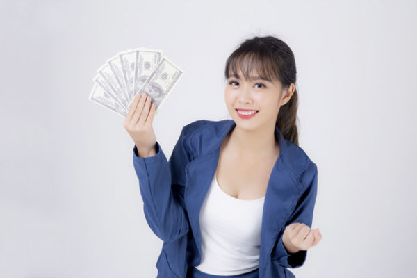 Ilustrasi perempuan megang uang. Foto: Shutterstock