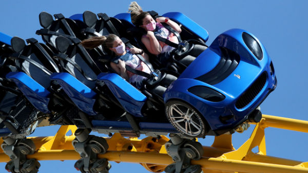 Orang-orang naik roller coaster di taman hiburan Six Flags Magic Mountain pada hari pertama pembukaan, di Valencia, California, AS,  Kamis (1/4). Foto: Lucy Nicholson/REUTERS