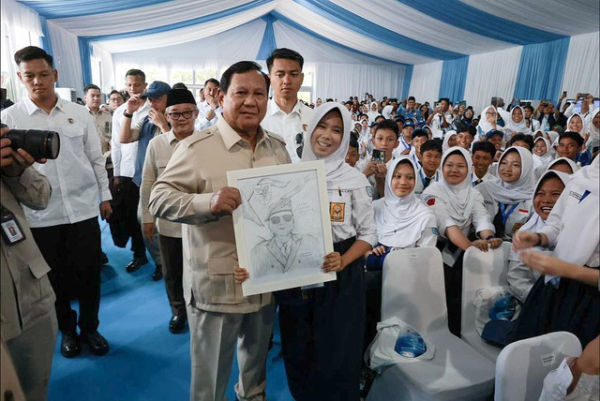 Presiden Prabowo Subianto menunjukkan lukisan dari seorang siswa saat peluncuran program Digitalisasi Pembelajaran Untuk Indonesia Cerdas di SMP Negeri 4 Bekasi, Jawa Barat, Senin (17/11/2025).  Foto: Instagram/@presidenrepublikindonesia