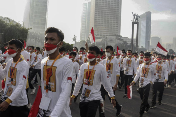 Sejumlah aktivis mengikuti Kirab Hari Pekerja Migran Internasional saat Hari Bebas Kendaraan Bermotor (HBKB) di Bundaran HI, Jakarta, Minggu (18/12/2022). Foto: Darryl Ramadhan/ANTARA FOTO