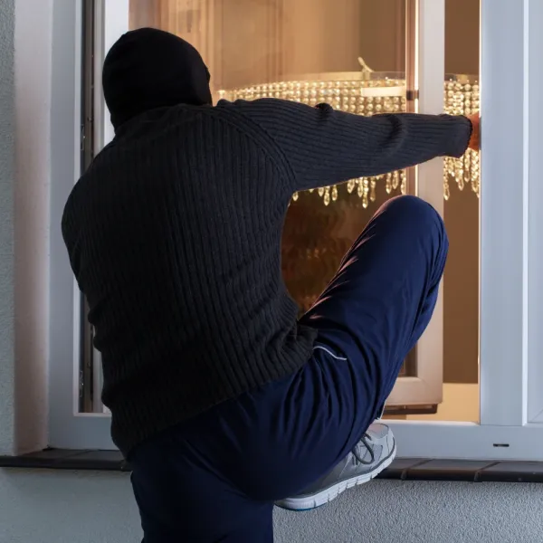 burglar climbing through a window