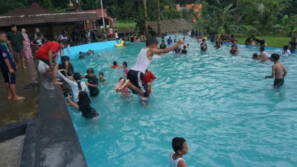 Pengunjung sedang renang di kolam mata air alami di Arenan Kalikesek.