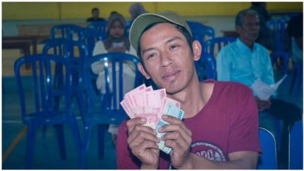 Seorang warga Desa Sriwulan memperlihatkan THR yang diberikan oleh BUMDes Sriwulan Makmur.