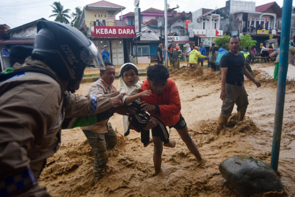 Petugas membantu evakuasi warga saat limpahan banjir bandang di kawasan Pasar Baru, Padang, Sumatera Barat, Jumat (28/11/2025). Foto: Iggoy el Fitra/ANTARA FOTO