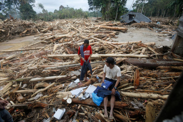 Warga memeriksa pakaian yang masih bisa diselamatkan usai terdampak banjir bandang di Batang Toru, Sumatera Utara, Selasa (2/12/2025). Foto: Binsar Bakkara/AP Photo