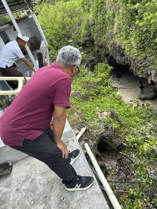 Petugas mengecek pipa saluran pembuangan bocor di sekitar tebing Pantai Suluban. Foto: Dok.  DLHK Badung
