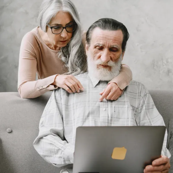 elderly man watching AI content on laptop