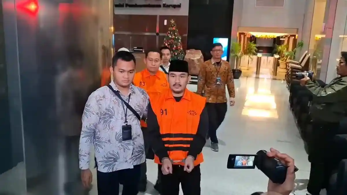 Bupati Bekasi, Ade Kuswara Kunang, saat digiring penyidik KPK menuju rumah tahanan usai ditetapkan sebagai tersangka suap, Jumat (19/12/2025).