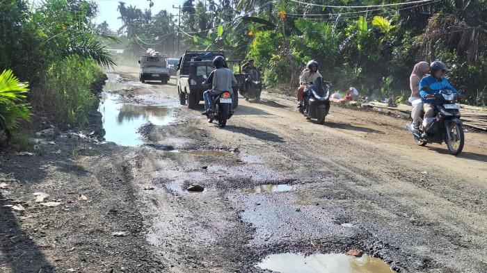 Pengendara melintas Jalan di Dusun Bumi Suci, Desa Bram Ita