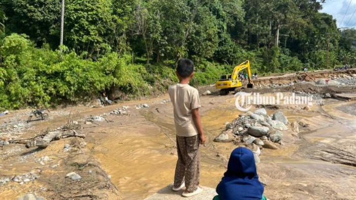 BANJIR BATU BUSUK: Jalan utama yang menghubungkan Kelurahan Kapalo Koto menuju Kelurahan Lambung Bukit kembali putus total akibat luapan deras aliran sungai, Selasa (23/12/2025) malam.