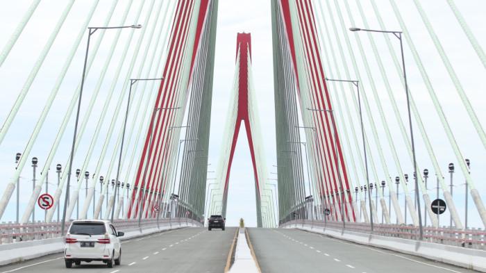 JALAN TOL IKN -  Warga melintas di jalan tol tepatnya di Jembatan Pulau Balang, Sabtu (20/12/2025).Hari pertama pembukaan fungsional Jalan Tol menuju Ibu Kota Nusantara (IKN) diwarnai dengan peningkatan arus kendaraan yang melintas di Jembatan Pulau Balang. (TRIBUNKALTIM.CO/DWI ARDIANTO)