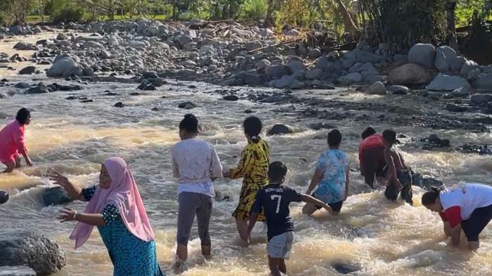 BANJIR PADANG: Aksi gotong royong warga Lapau Munggu, Kuranji, Padang pada Rabu (24/12/2025).Tanpa bantuan mesin, puluhan warga turun ke sungai untuk memindahkan bongkahan batu dan kayu besar hanya dengan mengandalkan kekuatan tangan.Upaya nekat ini dilakukan demi membuat tanggul darurat.