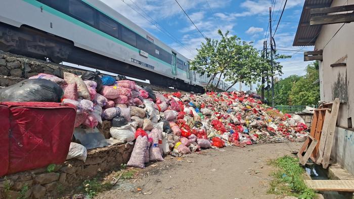 PENUMPUKAN SAMPAH BEKASI - Penumpukan sampah terlihat di pinggir rel kereta underpass Duren Jaya, Kecamatan Bekasi Timur, Kota Bekasi, Rabu (17/12/2025). (TribunBekasi/RendyRutamaPutra).
