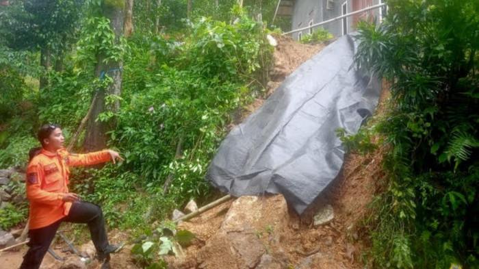 Petugas BPBD saat mengevakuasi rumah w