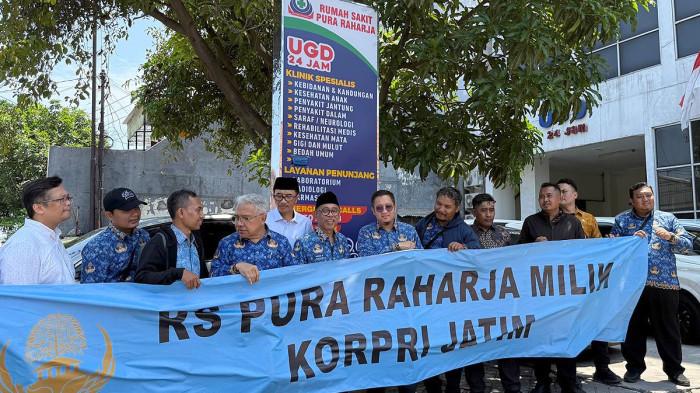 PERJUANGKAN ASET - Sejumlah ASN Pemprov Jatim bersegeragam KORPRI mendatangi RS Pura Raharja yang berlokasi di kawasan Pucang Adi, Surabaya, Jawa Timur, Jumat (5/12/2025) siang. Mereka membentangkan banner bertuliskan RS Pura Raharja Milik KORPRI Jawa Timur.