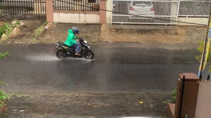 HUJAN- Pengendara sepeda motor saat melewati jalan yang basah diguyur hujan di Kecamatan Padang Timur, Kota Padang, Sumatera Barat, Selasa (30/12/2025).