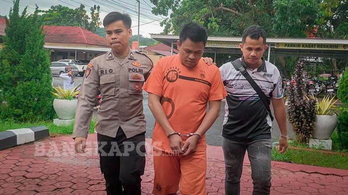 DIGIRING POLISI - Ander (28) tersangka dugaan kasus penganiayaan bermotif cemburu saat digiring petugas Unit PPA Satreskrim Polres Bangka Selatan menuju ruang pemeriksaan, Selasa (20/12/2025). Dari penangkapan polisi mengamankan berhasil menyita barang bukti berupa senjata tajam jenis pisau.