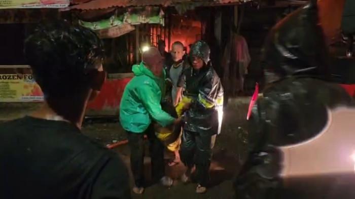 KEBAKARAN - Beberapa orang terlihat mengevakuasi seorang pedagangHHHT