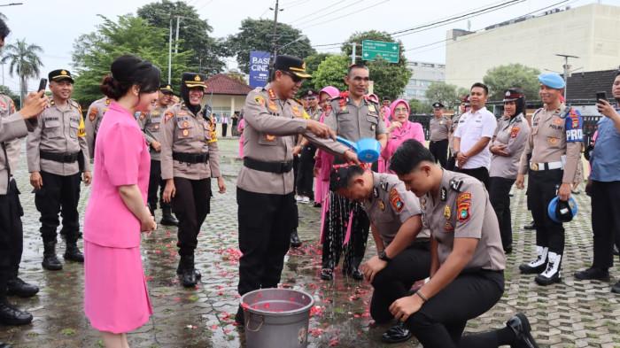 NAIK PANGKAT -- Kapolresta Pangkalpinang, Kombes Pol Max Mariners, saat menyiram anggota dan memberikan ucapan selamat kepada anggota yang naik pangkat di halaman Mapolresta, Rabu (31/12/2025).