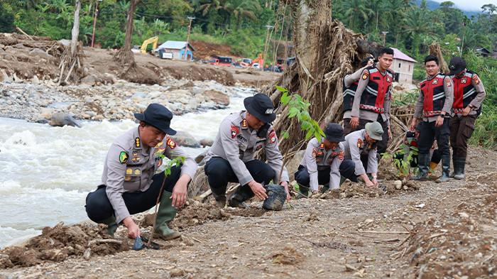 Tim Polda Riau menanam pohon di tepi Sungai Batang di Kecamatan Palembayan sebelum mengakhiri operasi kemanusiaan.