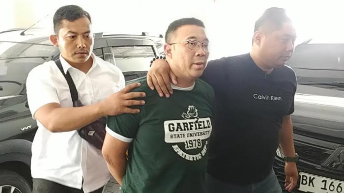 DIGELANDANG - Samuel Ardi Kristanto digelandang Anggota Unit II Subdit IV Renakta Ditreskrimum Polda Jatim di Surabaya, Senin (29/12/2025). Samuel disebut-sebut sebagai aktor utama di balik perobohan rumah yang berujung pengusiran paksa terhadap Nenek Elina Widjajanti (80)