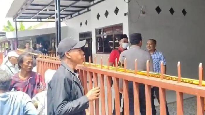 SATU KELUARGA TEWAS — Warga berkerumun saat polisi mengamankan TKP setelah penemuan jasad satu keluarga diduga korban pembunuhan di rumah mereka, Desa Demung, Kecamatan Besuki, Situbondo, Jawa Timur, Minggu (28/12/2025).