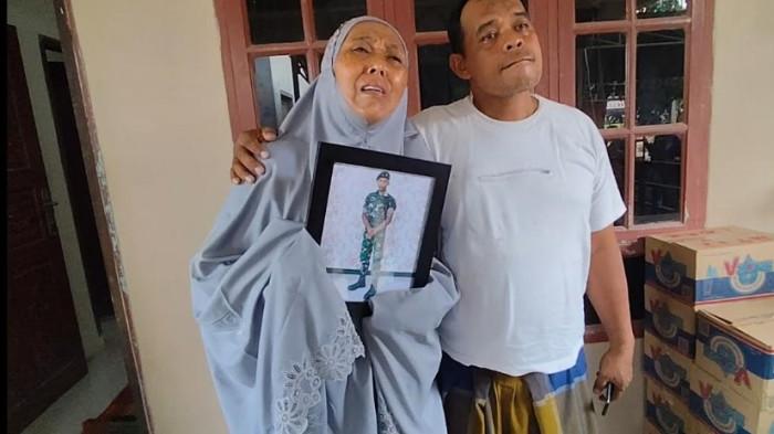 Ibu Pratu Farkhan Syauqi Marpaung, Marsinah Wati Silalahi terkulai memeluk bingkai foto anaknya di rumah duka, Dusun IV, Desa Hessa Air Genting, Air Batu, Kabupaten Asahan, Jumat (2/1/2026). Setelah dikabarkan meninggal dunia dalam tugas di perbatasan Indonesia - Papua Nugini. (Alif Alqadri Harahap/tribun-medan.com)