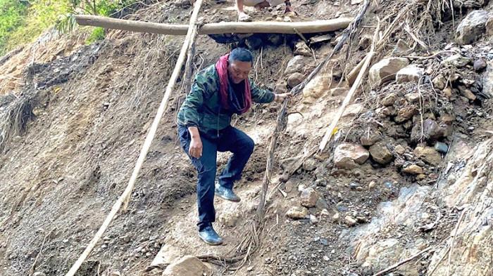 TEROBOS JALAN LONGSOR - Bupati Gayo Lues, Suhaidi saat mencoba menerobos tumpukan material longsor yang menutupi badan jalan Blangkejeren menuju Kecamatan Pining saat mengunjungi posko pengungsian korban banjir bandang, Senin (22/12/2025).