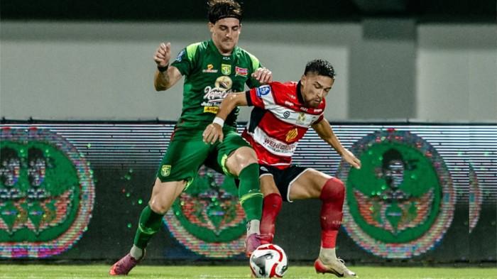 DUEL - Pemain Persebaya Surabaya, Dejan Tumbas (kaus hijau) berduel dengan pemain Madura United  dalam perebutan bola di Stadion Gelora Madura Ratu Pamelingan, Pamekasan, Jawa Timur, Sabtu (3/1/2026) malam. Babak pertama berakhir imbang 0-0.