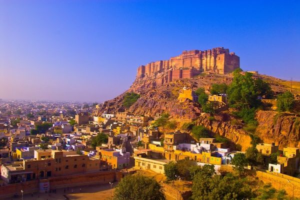 This may contain: an aerial view of the city of jodhpur, india with mountains in the background