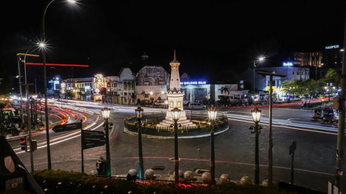Tugu Yogyakarta, ikon kota Jogja yang menjadi pusat landmark dekat dengan malioboro dan sering dikunjungi wisatawan, terlihat indah di malam hari dengan latar jalanan sekitar.