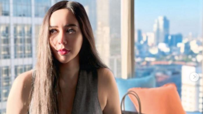 GOSIP RIDWAN KAMIL - Aktris Aura Kasih denga rambut panjang teruurai berpose dengan latar belakang gedung-gedung tinggi yang dibagikan melalui Instagram pribadi-nya pada Kamis (10/7/2025). Koleksi barang mewah hingga deretan aset milik Aura Kasih mendadak menjadi pusat perhatian netizen setelah namanya ikut terseret dalam pusaran isu terkait Mantan Gubernur Jawa Barat, Ridwan Kamil. 