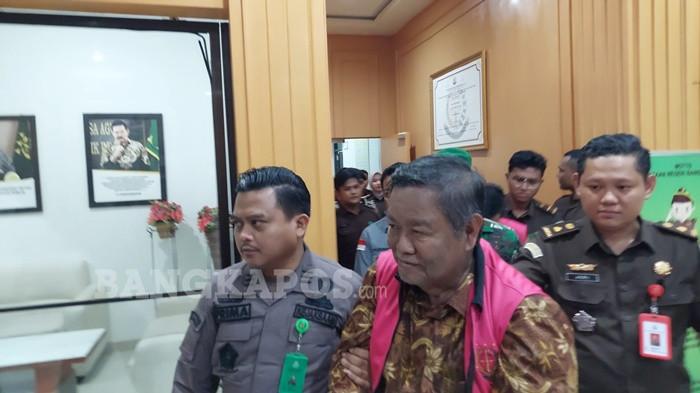DIGIRING PETUGAS - Mantan Bupati Bangka Selatan, Justiar Noer dan mantan Camat Lepar, Dodi Kusumah ketika digiring menuju mobil tahanan Kejaksaan Negeri Bangka Selatan, Kamis (11/12/2025) malam. Keduanya resmi ditetapkan sebagai tersangka atas dugaan tindak pidana korupsi dengan kerugian mencapai Rp45,964 miliar.