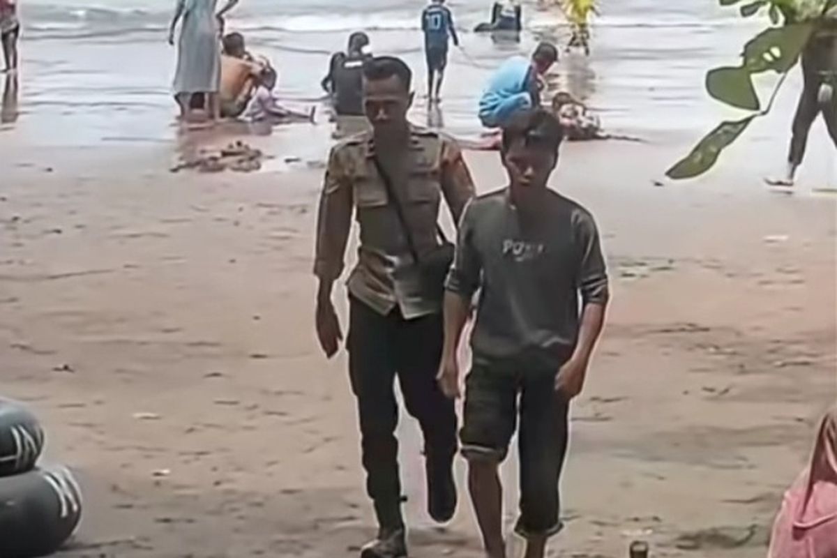 Wandi diantar anggota Polsek Cijulang bermain air di Pantai Batukaras, Kecamatan Cijulang, Jumat (2/1/2026).