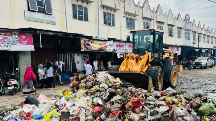 TUMPUKAN SAMPAH - Pemerintah Kecamatan Wonomulyo mengerahkan satu unit alat berat dan lima truck angkut tumpukan sampah di Kompleks Pasar Wonomulyo, Kabupaten Polman, Sulbar, Kamis (8/1/2026). Sampah diangkut ke TPA Balanipa.