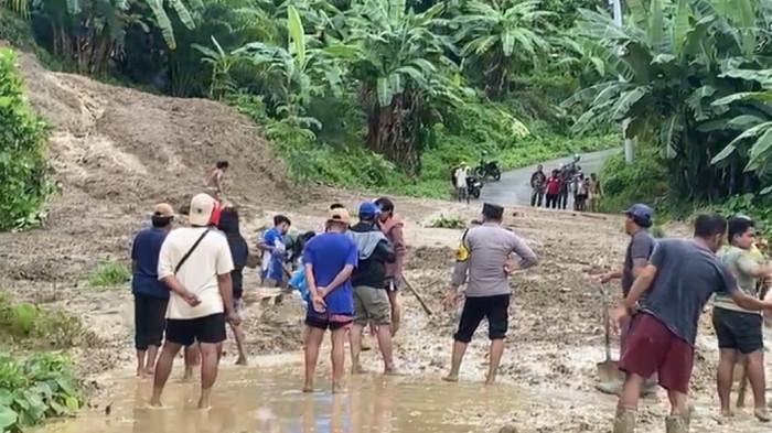 TANAH LONGSOR-Puluhan warga dan aparat TNI-Polri saat membersihkan tanah dan lumpur dari longsor yang menutup akses jalan di Desa Pangiang, Kecamatan Bambalamotu, Kabupaten Pasangkayu, Kamis (8/1/2026). Sebanyak 9 dusun yang terisolir akibat longsor ini.